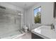 Modern bathroom with a glass-enclosed shower, sleek vanity, and natural light from a side window at 5217 Tanglewild Dr, Raleigh, NC 27613