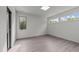 Bright bedroom features minimalist design, three windows and light gray flooring at 5217 Tanglewild Dr, Raleigh, NC 27613