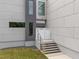 Stylish home entrance featuring a modern staircase and sophisticated gray and white facade at 5217 Tanglewild Dr, Raleigh, NC 27613