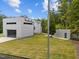 Modern home with glass garage doors, an outbuilding, and a spacious, well-manicured lawn at 5217 Tanglewild Dr, Raleigh, NC 27613