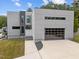 Modern home showcasing sleek architecture, a glass-paneled garage door, and manicured landscaping at 5217 Tanglewild Dr, Raleigh, NC 27613