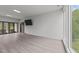 Bright living room featuring hardwood floors, a wall-mounted TV, and access to an outdoor balcony with scenic views at 5217 Tanglewild Dr, Raleigh, NC 27613