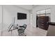 Contemporary office space with hardwood flooring, a wall-mounted TV, and a modern glass desk at 5217 Tanglewild Dr, Raleigh, NC 27613