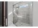 Close-up of a tiled walk-in shower with a glass door and rainfall shower head at 5217 Tanglewild Dr, Raleigh, NC 27613