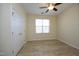 Neutral bedroom featuring a window, closet, ceiling fan, and light-colored walls and floors at 528 Weather Ridge Ln, Cary, NC 27513