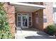 Charming brick condo entrance with a cozy bench and well-lit doorway at 528 Weather Ridge Ln, Cary, NC 27513