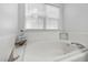 Bright bathroom showcasing a pristine white tiled tub under a window with natural light at 5401 Green Feather Ln, Raleigh, NC 27604