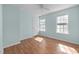Bright bedroom featuring beautiful light blue walls, wood floors, and windows at 5401 Green Feather Ln, Raleigh, NC 27604
