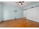 Bedroom with light blue walls, hardwood floors, ceiling fan, and a barn door style closet at 5401 Green Feather Ln, Raleigh, NC 27604