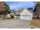 View of the home with a driveway leading to a two-car garage and inviting front porch at 5401 Green Feather Ln, Raleigh, NC 27604