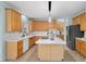 Well-lit kitchen featuring honey oak cabinetry, a center island with gas stovetop, and stainless steel appliances at 5401 Green Feather Ln, Raleigh, NC 27604