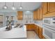 Light-filled kitchen with honey oak cabinets, a center island with a gas stovetop, and a view to the patio at 5401 Green Feather Ln, Raleigh, NC 27604
