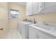 Laundry room with white cabinets, sink, and white washer and dryer set near a window at 5401 Green Feather Ln, Raleigh, NC 27604