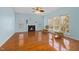Light-filled living room with fireplace, hardwood floors, and charming chairs at 5401 Green Feather Ln, Raleigh, NC 27604