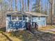 Charming single-story home with blue siding, surrounded by a beautiful wooded area with a welcoming front porch at 5500 Bobbitt Rd, Apex, NC 27539