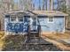 Charming single-story home with blue siding, surrounded by a beautiful wooded area with a welcoming front porch at 5500 Bobbitt Rd, Apex, NC 27539