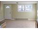 Bright and airy living room boasts neutral carpet, large windows, and a heater providing comfort in any season at 5500 Bobbitt Rd, Apex, NC 27539