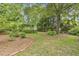 Lush backyard with a shed, arbor, swing set, and mature trees at 613 S Fuquay Ave, Fuquay Varina, NC 27526