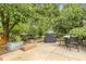 Spacious backyard patio with a grill, seating, and a garden surrounded by mature trees at 613 S Fuquay Ave, Fuquay Varina, NC 27526
