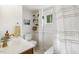 Bright bathroom featuring a shower, vanity, toilet, and storage shelves at 613 S Fuquay Ave, Fuquay Varina, NC 27526