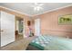 Bedroom featuring pink walls, white trim, with access to additional room or closet at 613 S Fuquay Ave, Fuquay Varina, NC 27526