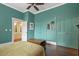 Bedroom with teal walls, a ceiling fan, a bed, and a view of the ensuite bathroom at 613 S Fuquay Ave, Fuquay Varina, NC 27526