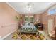 Charming pink bedroom with rug, desk, sitting area, and ample natural light from multiple windows at 613 S Fuquay Ave, Fuquay Varina, NC 27526