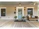 Inviting front porch with a wood deck, seat, vintage outdoor lighting, and a painted door at 613 S Fuquay Ave, Fuquay Varina, NC 27526