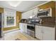 Cozy kitchen featuring stainless steel appliances, white cabinets, and a window bringing in lots of natural light at 613 S Fuquay Ave, Fuquay Varina, NC 27526