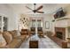 Inviting living room with fireplace, neutral sofa, and large ceiling fan at 613 S Fuquay Ave, Fuquay Varina, NC 27526