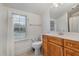 Bright bathroom with vanity, toilet, and shower with a view to the neighborhood at 705 Hinsdale St, Raleigh, NC 27605