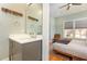 Well lit bathroom with large mirror over the vanity and a view into the bedroom at 705 Hinsdale St, Raleigh, NC 27605
