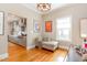 Sitting area featuring hardwood floors, natural light, and views into an updated kitchen at 705 Hinsdale St, Raleigh, NC 27605