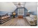 An attic bedroom features wood flooring, a window, a ceiling fan, and a comfortable couch at 761 Raymond Dr, Clayton, NC 27527