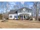 Charming two-story home featuring a covered porch, black shutters and mature landscaping at 761 Raymond Dr, Clayton, NC 27527
