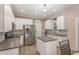 Bright kitchen featuring stainless steel appliances, white cabinets, an island, and a tile backsplash at 761 Raymond Dr, Clayton, NC 27527