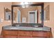 Bathroom featuring a double sink vanity with granite countertops and large mirror at 7709 Moondance Ct, Wake Forest, NC 27587
