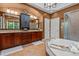 Bathroom with double vanity, storage, and a soaking tub with shower in an alcove at 7709 Moondance Ct, Wake Forest, NC 27587
