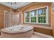 Bright bathroom features a relaxing soaking tub and large window with a private, wooded view at 7709 Moondance Ct, Wake Forest, NC 27587