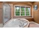 Bright bathroom features a relaxing soaking tub and large window with a private, wooded view at 7709 Moondance Ct, Wake Forest, NC 27587