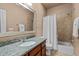 Bathroom with neutral tones features a tiled shower/tub and granite countertop vanity at 7709 Moondance Ct, Wake Forest, NC 27587