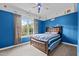 Bright blue bedroom with a large window for natural light and a bed at 7709 Moondance Ct, Wake Forest, NC 27587