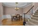 Formal dining area with decorative chandelier, beautiful hardwood floors, and adjacent staircase at 7709 Moondance Ct, Wake Forest, NC 27587