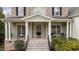 Inviting front porch with classic columns, comfortable seating, and a welcoming entrance at 7709 Moondance Ct, Wake Forest, NC 27587