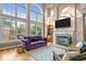 Bright living room features tall windows, a cozy fireplace, and stylish decor for comfortable living at 7709 Moondance Ct, Wake Forest, NC 27587
