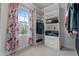 Walk-in closet with custom shelving and colorful floral curtains accenting the bright window at 7709 Moondance Ct, Wake Forest, NC 27587