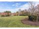 Spacious backyard with manicured lawn, elegant landscaping, and a black metal fence creating a private oasis at 9041 Chelsea Dr, Raleigh, NC 27603