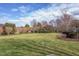 Expansive backyard featuring lush green grass, mature trees, and a secure fence, ideal for outdoor activities at 9041 Chelsea Dr, Raleigh, NC 27603
