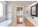 Well-lit bathroom with a soaking tub, wood vanity and view into the main bedroom at 9041 Chelsea Dr, Raleigh, NC 27603