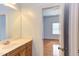 Bathroom features a marble topped vanity with wood cabinets next to the entryway of the light blue bedroom at 9041 Chelsea Dr, Raleigh, NC 27603